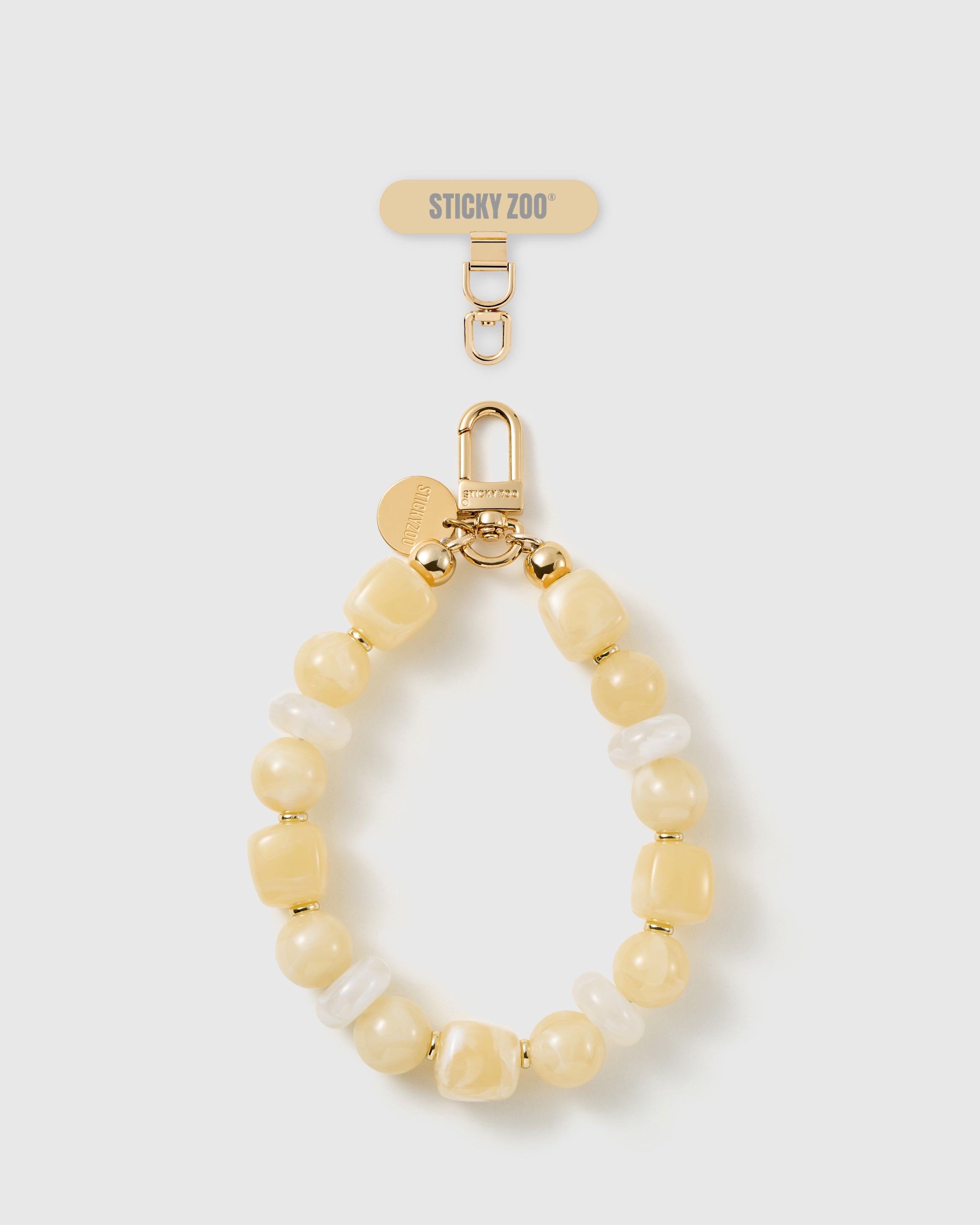 Handmade buttermilk beaded phone strap by STICKYZOO with 18K gold-plated engraved hardware