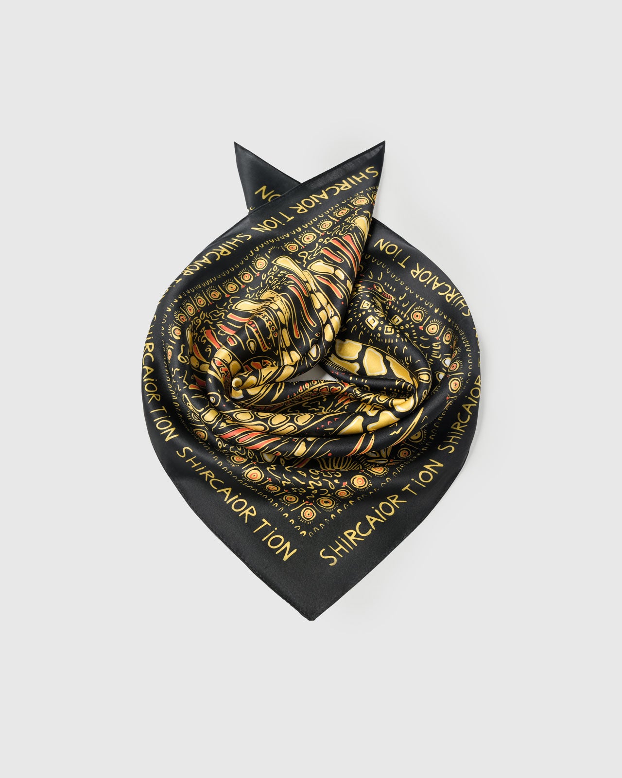 Silk scarf coiled to show the soft drape and the gold giraffe print holding its color on pure silk