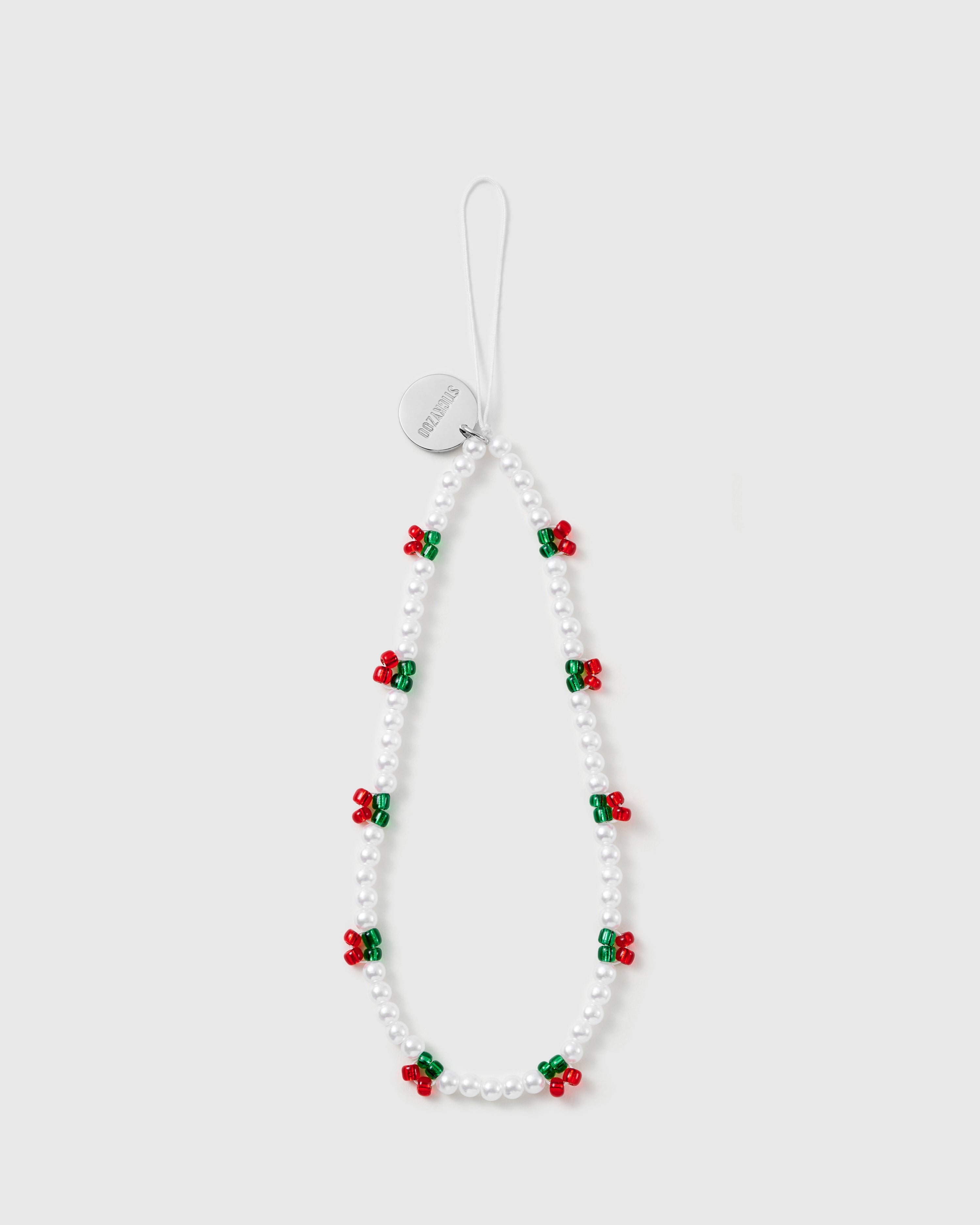 STICKYZOO holly-berry phone strap laid flat: white faux-pearl beads with red-and-green berry clusters and a silver-tone engraved disc.