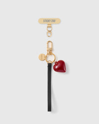 STICKYZOO crimson heart phone strap with a black textured wristlet, 18K gold-plated hardware and the included Phone Strap Card