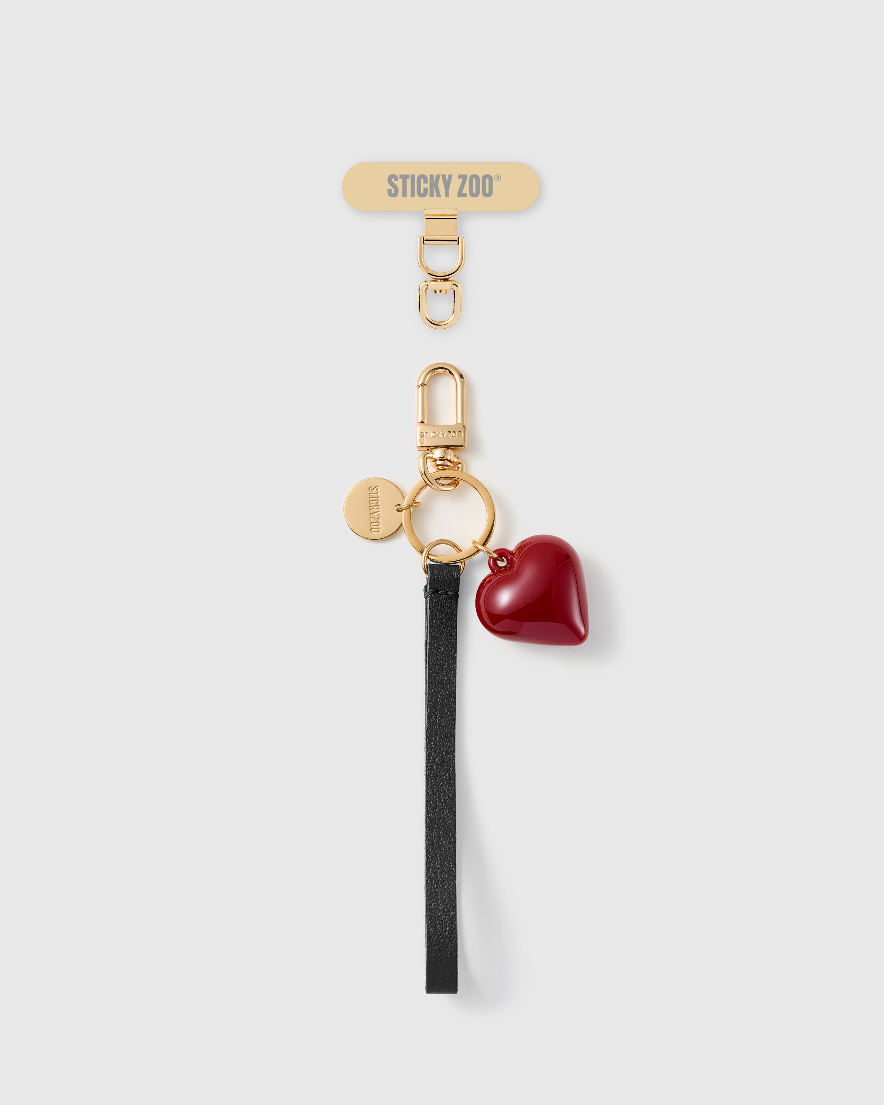 STICKYZOO crimson heart phone strap with a black textured wristlet, 18K gold-plated hardware and the included Phone Strap Card