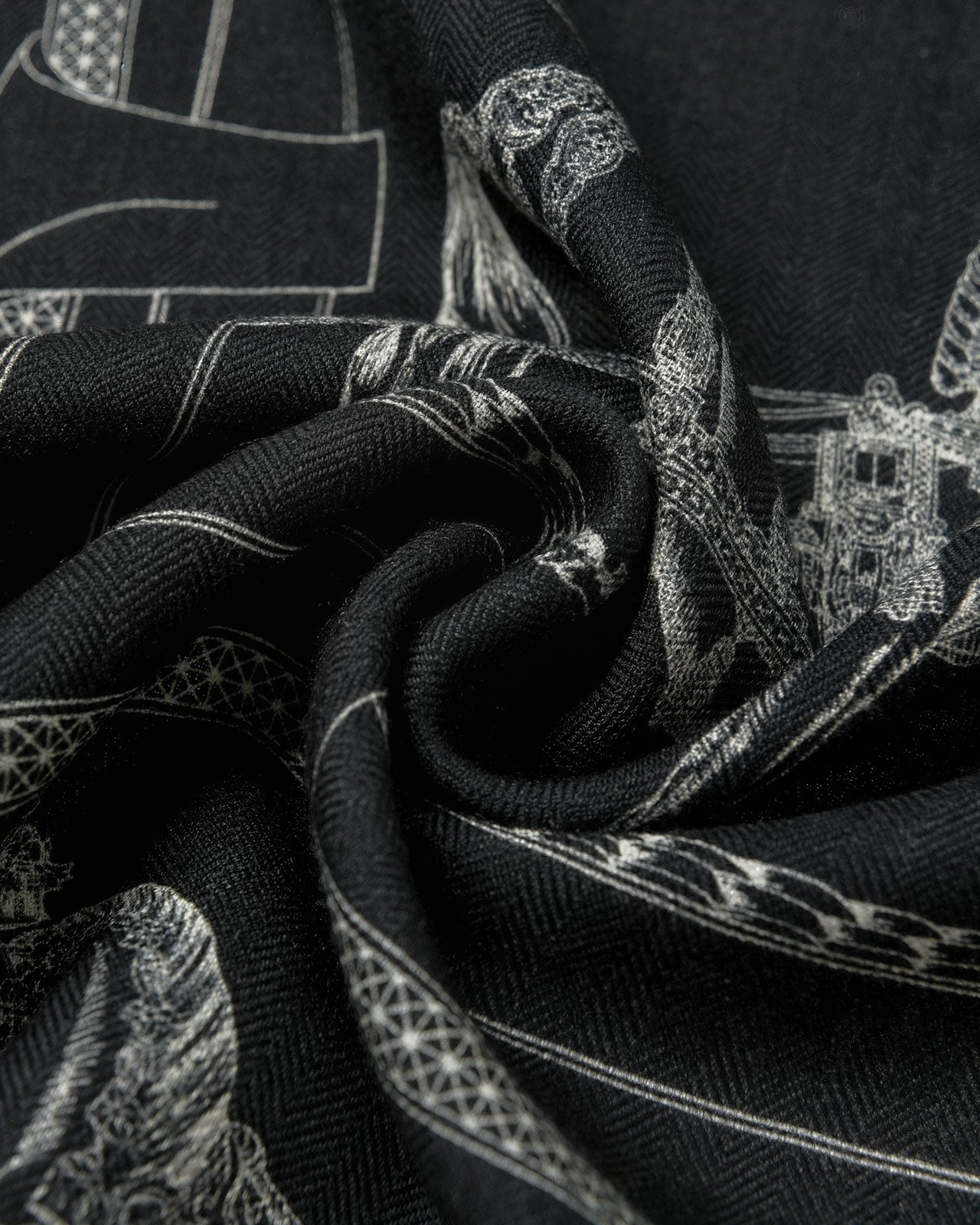 Silk noir engraving scarf coiled through a leather ring showing the black ground and ivory motif