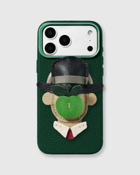 Green vegan leather phone case with detachable handmade French Alran leather Son of Man charm featuring bowler hat, green apple, suit, and red tie. Designed in Amsterdam.