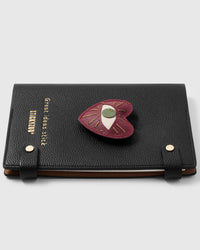 French Alran leather evil eye heart talisman charm detail showing hand-cut and hand-stitched layers with engraved gold-plated hardware