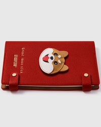 Shiba Inu face charm detail showing hand-layered tan and white leather with pink tongue on STICKYZOO A5 notebook