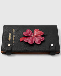 French Alran leather lucky clover charm detail showing hand-cut and hand-stitched layers with engraved gold-plated hardware