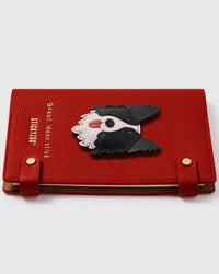Border collie face charm detail showing hand-layered black and white leather with red tongue on STICKYZOO A5 notebook