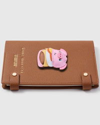 Pork fillet cheeseburger charm detail showing multi-layered leather — bun, cheese, lettuce, pink pig face on STICKYZOO notebook