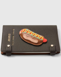 French Alran leather hotdog charm detail showing hand-cut and hand-stitched leather layers on STICKYZOO notebook