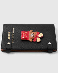 French Alran leather teddy gift box charm detail showing hand-cut and hand-stitched layers with engraved gold-plated hardware