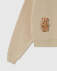 Detail of plush teddy bear and ribbed cuff on cream 450gsm cotton fleece
