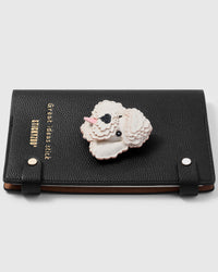 French Alran leather poodle charm detail showing hand-cut and hand-stitched layers with engraved gold-plated hardware