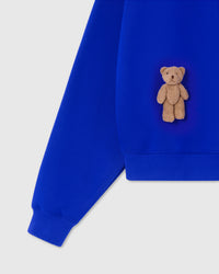 Detail of plush teddy bear and ribbed cuff on blue 450gsm cotton fleece