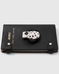 French Alran leather dalmatian charm detail showing hand-cut and hand-stitched layers with engraved gold-plated hardware