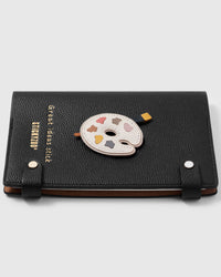 French Alran leather artist palette charm detail showing hand-cut and hand-stitched layers with engraved gold-plated hardware