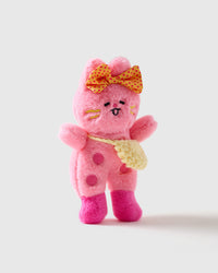 Handmade plush bunny detail | Close-up of pink plush bunny doll with embroidered happy face, yellow polka-dot bow, pink button details, hot pink boots, and yellow knit crossbody bag