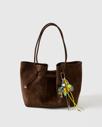 Clips onto any bag | Banana Rally Stack Charm on dark brown suede tote showing banana figure, tennis racket and ball, dice cluster, and yellow braided paracord ropes with metal tips