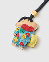 Both editions of the classic Shinchan charm — leather strap loop for bags, or 18K gold-plated keychain clip.