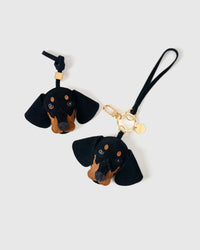 Close-up of handmade Dachshund suede bag charm — hand-stitched visible edges on French Alran suede, hand-layered black-and-tan markings. STICKYZOO Amsterdam design.