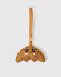 CRISPY CROISSANT MOOD charm handmade from French Alran suede — real full-grain French leather from Tarn, since 1903. Three days of hand-cutting, hand-stitching, hand-layering. Arrives in luxury gift packaging. Designed in Amsterdam.