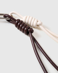 Close-up of the knotted faux-leather cords and stainless steel clip on the POODLEGRAM charm by STICKYZOO