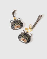 Both gray-olive editions of the American Shorthair — leather strap loop for bags, or 18K gold-plated keychain clip with engraved disc.