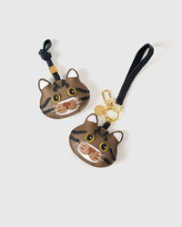 Both brown-tabby editions of the American Shorthair — leather strap loop for bags, or 18K gold-plated keychain clip with engraved disc.