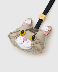 Tight detail of the silver Maine Coon face — the layered fluff around the cheeks, pink ear interiors in soft suede, yellow eyes in real leather. Every panel by hand.