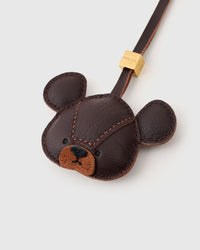 Both editions of the bear charm — leather strap loop for bags, or 18K gold-plated keychain clip.