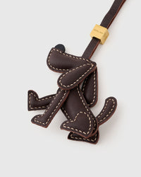 Close-up of handmade Basset Hound leather bag charm — hand-stitched visible edges on French Alran goatskin. STICKYZOO.