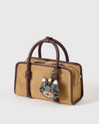 Gray-olive American Shorthair on a tan suede top-handle bag, side angle — rated 4.9★ by thousands of buyers. Real French Alran leather, 3 days by hand.