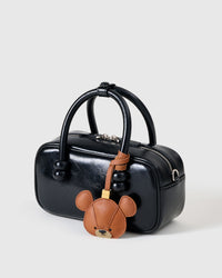 Both editions of the bear charm — leather strap loop for bags, or 18K gold-plated keychain clip.