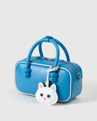 White British Shorthair charm on a vivid blue box bag, side angle — loved by thousands of cat lovers. Real French leather, 3 days by hand.