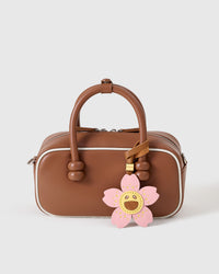 STICKYZOO Bloomy Sakura Charm — hand-cut, hand-stitched five sakura petals with smiley face centre in French Alran goatskin. Designed in Amsterdam.