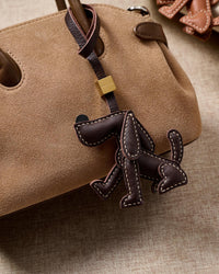 Handmade Basset Hound leather bag charm on a handbag — 3 days of hand-cutting and hand-stitching in French Alran goatskin. STICKYZOO.