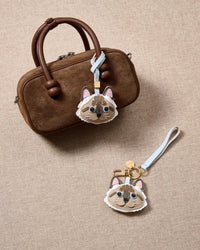 Tight close-up of the point-color Ragdoll charm face — every detail in real French Alran leather, layered and stitched by hand.
