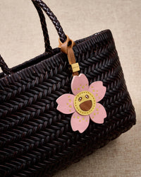 STICKYZOO Bloomy Sakura Charm — hand-layered French Alran goatskin, five sakura petals with smiley face centre. Designed in Amsterdam.