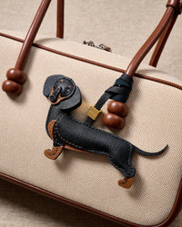 Close-up of handmade full-body Dachshund bag charm — hand-stitched belly seam, hand-layered tan paws on French Alran goatskin. STICKYZOO Long Dash.