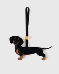 Handmade full-body Dachshund bag charm by STICKYZOO — hand-cut, hand-stitched, hand-layered French Alran suede over 5 days. Long Dash silhouette. Designed in Amsterdam.