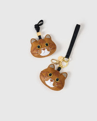 Both editions of the ginger British Shorthair side by side. French Alran leather from Tarn, France — founded 1903, Entreprise du Patrimoine Vivant.
