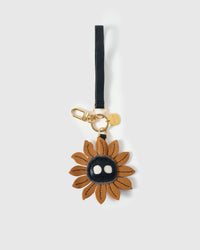 STICKYZOO Sunflower Mood Charm with engraved gold hardware cube — handmade French Alran goatskin, caramel with dark character centre.