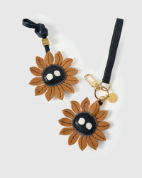 STICKYZOO Sunflower Mood Charm in caramel with dark character centre — handmade French Alran goatskin with 18K gold-plated hardware. Arrives gift-ready.