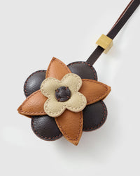 STICKYZOO Petal Espresso Charm clipped to a handbag — handmade French Alran goatskin in dark chocolate, caramel, and cream. 3-day artisan build.