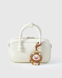 LION CHARM charm styled on a bag — a small, specific piece that turns a simple bag into a personal one.