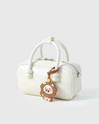 Both editions of the lion charm — leather strap loop for bags, or 18K gold-plated keychain clip.