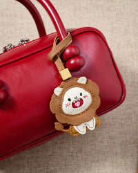Close-up of the lion charm — hand-cut and hand-stitched panels of French Alran goatskin. Every layer by hand.