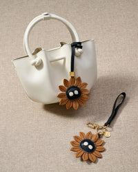STICKYZOO Sunflower Mood Charm — hand-cut, hand-stitched sunflower petals with character face in French Alran goatskin. Designed in Amsterdam.