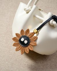 Close-up of STICKYZOO Sunflower Mood Charm — full-grain French Alran goatskin from Tarn, France. Sunflower petals with character face. 3-day handmade piece.