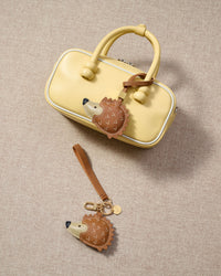 Close-up of the hedgehog charm — hand-cut and hand-stitched panels of French Alran goatskin. Every layer by hand.