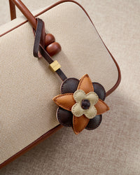 Close-up of STICKYZOO Petal Espresso Charm — full-grain French Alran goatskin from Tarn, France. Three-tier layered flower. 3-day handmade piece.